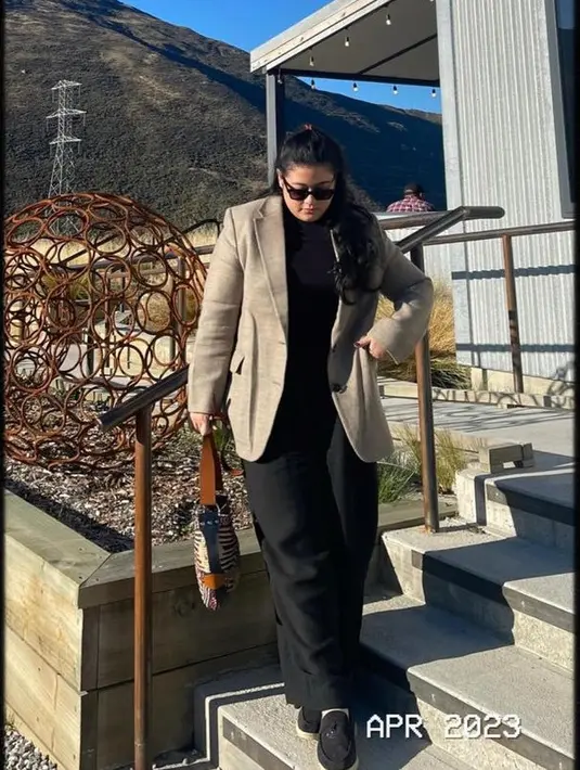 Ia juga tampil bergaya lady boss, mengenakan blazer coklat dipadukan inner dan celaan hitam. Serasi dengan alas kakinya. [@dpophaprani]