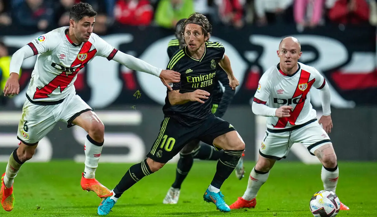 Pemain Real Madrid Luka Modric (tengah) berebut bola dengan pemain Rayo Vallecano Santi Comesana pada pertandingan sepak bola Liga Spanyol di Stadion Vallecas, Madrid, Spanyol, 7 November 2022. Rayo Vallecano mengalahkan Real Madrid dengan skor 3.2. (AP Photo/Manu Fernandez)