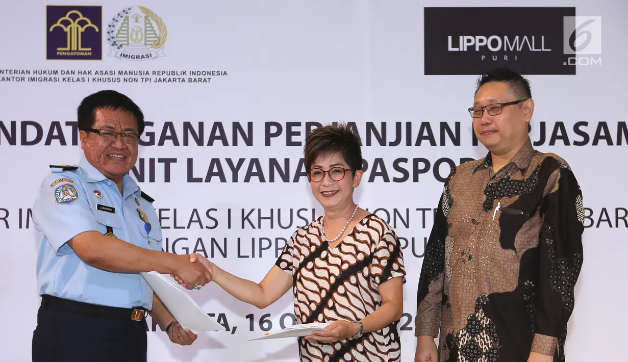 Kepala Kantor Imigrasi Kelas I Khusus Jakarta Barat, Lumaksono bersalaman dengan Direktur Lippo Mall Puri, Rita Yovita usai menandatangani MOU kerjasama pembukaan gerai layanan paspor di Lippo Mall Puri, Jakarta, Selasa (16/10). (Merdeka.com/Arie Basuki)