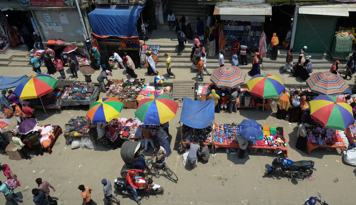 Warga memadati jalan yang dipenuhi lapak pedagang di area pasar tradisional selama karantina wilayah masih diberlakukan pemerintah setempat di Dhaka, Bangladesh (12/5/2020). (AFP/Munir Uz Zaman)