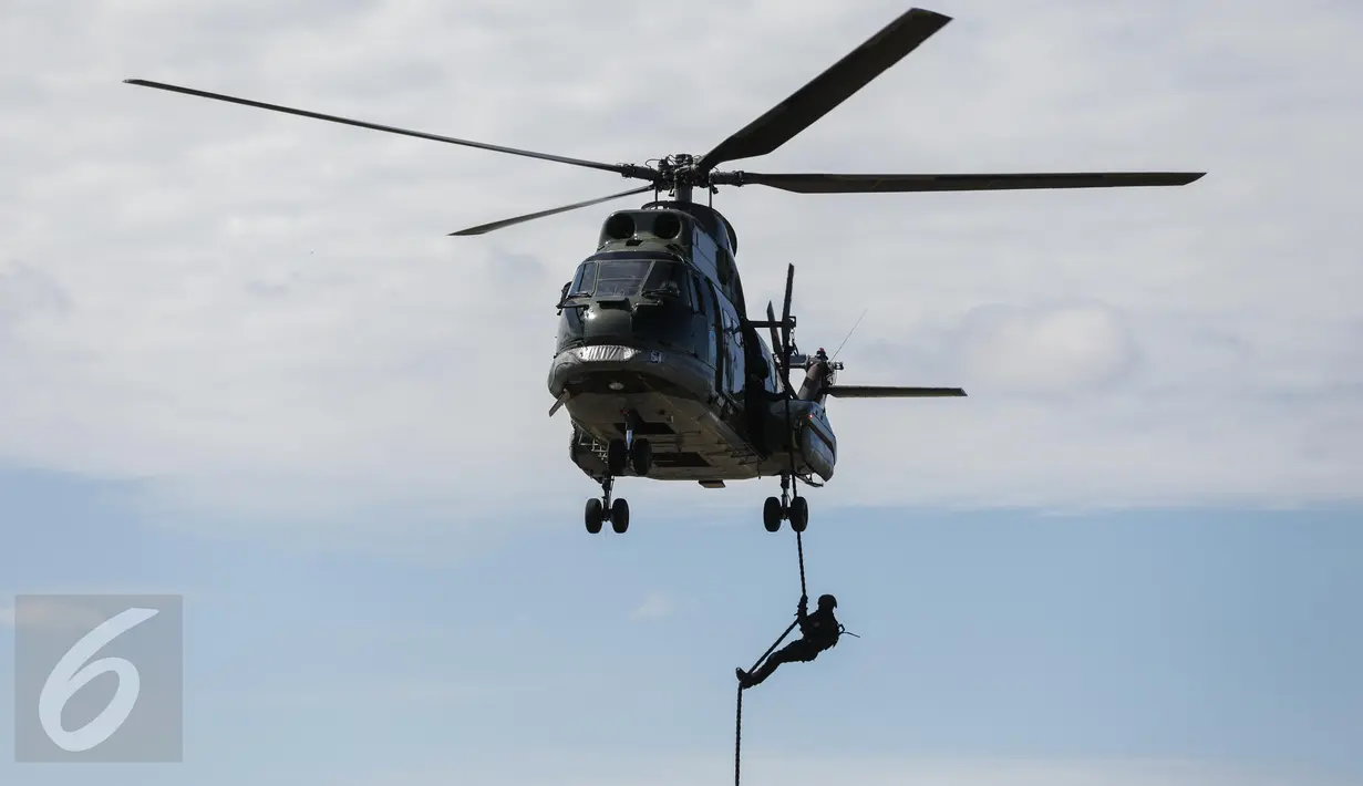 Anggota Paskhas (Pasukan Khas) TNI AU menuruni helikopter menggunakan tali saat unjuk kebolehan simulasi penyelamatan sandera dalam rangkaian acara HUT TNI AU di Halim Perdanakusuma, Minggu (9/4). TNI AU memperingati HUT ke-71 (Liputan6.com/Faizal Fanani)