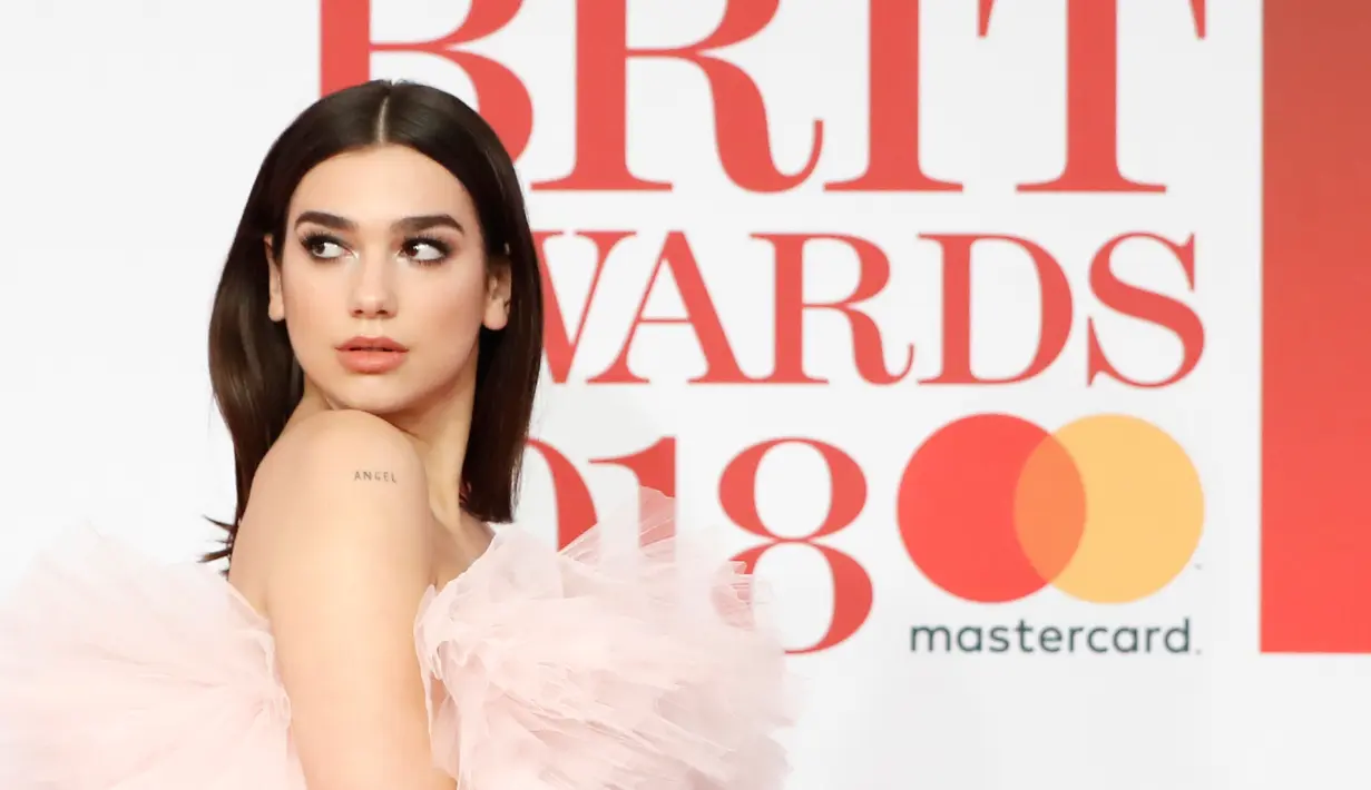 Penyanyi cantik Dua Lipa berpose untuk fotografer setibanya di karpet merah acara Brit Awards 2018 di O2 Arena, London, Rabu (21/2). Penyanyi berusia 22 tahun ini terlihat cantik dengan gaun ala princess yang dikenakannya. (Tolga AKMEN / AFP)