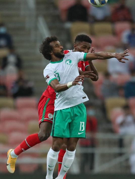 Pemain Arab Saudi Yasser Al-Shahrani (depan) berebut sundulan dengan pemain Oman Amjad al-Harthi (belakang) pada pertandingan sepak bola Kualifikasi Piala Dunia 2022 di Stadion King Abdullah Sport City, Jeddah, Arab Saudi, 27 Januari 2022. Arab Saudi menang 1-0. (AFP)