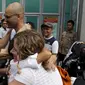 Ferdinant Tjiong (kiri) dan Neil Bantleman ditemani para istri berpelukan di depan penjara Cipinang, Jakarta (14/8/2015). Dua guru Jakarta International School (JIS) Ferdinant dan Neil diputus bebas oleh Pengadilan Tinggi Jakarta. (REUTERS/Beawiharta)