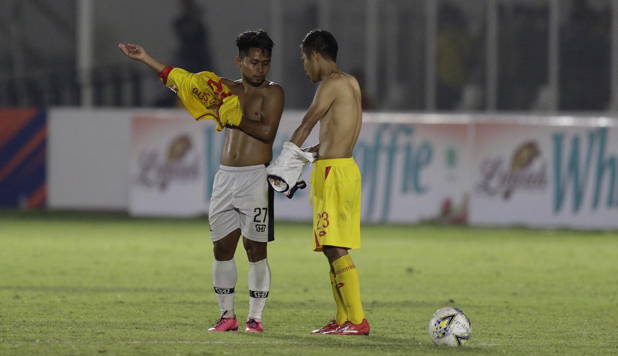 Gelandang Madura United, Andik Vermansah, bertukar jersey dan celana dengan gelandang Bhayangkara FC, Wahyu Suboseto, pada laga Liga 1 2019 di Stadion Madya, Jakarta, Senin (5/8). Kedua tim bermain imbang 1-1. (Bola.com/M iqbal Ichsan)