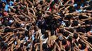 Umat Hindu membentuk piramida manusia selama Festival Janmashtami di Mumbai, India, 24 Agustus 2019. Piramida manusia itu untuk memecahkan pot berisikan suus yang menggangtung di langit-langit rumah supaya bisa diambil isinya. (AP Photo/Rajanish Kakade)