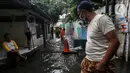 Warga beraktivitas saat banjir merendam lingkungan rumah tempat tinggal mereka di kawasan kecamatan Kebayoran Baru, Jakarta, Senin (25/01/2021). Hujan deras yang mengguyur Jakarta hari ini, Senin (25/1) menyebabkan terjadinya banjir di kawasan permukiman tersebut. (Liputan6.com/Johan Tallo)