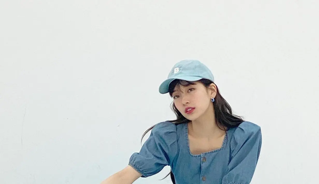 Tampil cantik di segala outfit membuat Bae Suzy mudah dalam memadukan busana. Untuk kamu ingin tampil sporty namun terlihat feminin, bisa mengenakan denim jumpsuit dengan detail puffed sleeve dari Guess. High Top sneakers dan topi navy menjadi sentuhan sporty yang effortless. (instagram/skuukzky)
