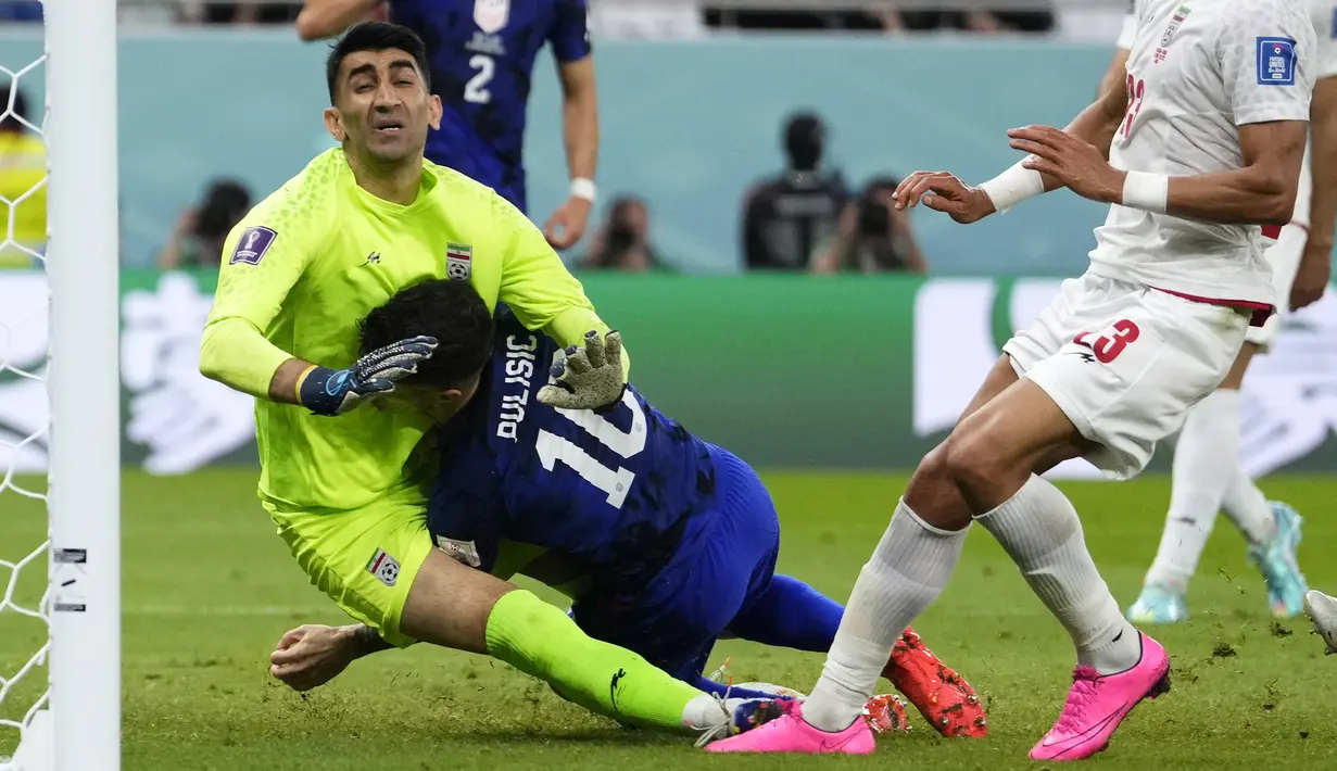 Gelandang Amerika Serikat Christian Pulisic (tengah) bertabraan dengan kiper Iran Alireza Beiranvand setelah mencetak gol pertama timnya pada laga pamungkas Grup B Piala Dunia 2022 di Stadion Al Thumama, Rabu (30/11/2022) dini hari WIB.  Christian Pulisic menjadi pahlawan keberhasilan Amerika Serikat lolos ke babak 16 besr Piala Dunia 2022. (AP Photo/Manu Fernandez)