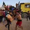 Pengungsi Palestina membawa kotak-kotak bantuan kemanusiaan yang diambil dari truk pengangkut di dekat Nuseirat di Jalur Gaza tengah pada 18 Mei 2024. (Foto: AFP)