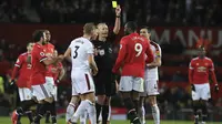 Pemain Manchester United, Romelu Lukaku menerima kartu kuning dari wasit Martin Atkinson saat melwan Burnley pada lanjutan Premier League di Old Trafford,  Manchester (26/12/2017).  MU bermain imbang 2-2. (AFP/Lindsey Parnaby)