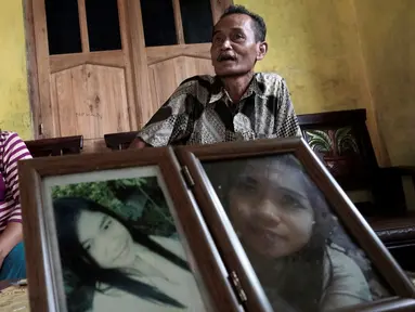 Ahmad Kaliman dan Suratmi orang tua dari Sumarti Ningsih, seorang wanita Indonesia yang dibunuh oleh Rurik Jutting Karyawan Bank of America Merrill Lynch di Hong Kong di desa mereka di Cilacap, Jawa Tengah , Indonesia (8/11). (REUTERS/Idhad Zakaria)