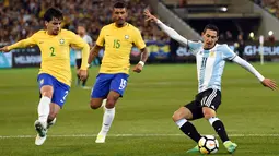 Gelandang Argentina, Angel Fabian Dimaria berusaha mengumpan bola dari kawalan dua pemain Brasil Lemos dan Maciel Junior pada laga persahabatan di MCG di Melbourne (9/6). Argentina menang atas Brasil dengan skor 1-0. (AFP Photo/Saeed Khan)