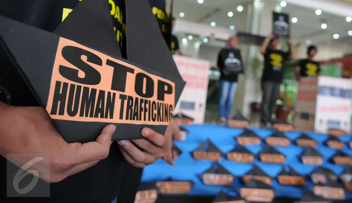 Poster bertuliskan Stop Human Trafficking' saat aksi protes di depan Kemenaker, Jakarta, Jumat (9/12). Sejumlah aktivis mendesak Pemerintah memperbaiki kebijakan penempatan buruh migran anak buah kapal asing di luar negeri. (Liputan6.com/Helmi Afandi)