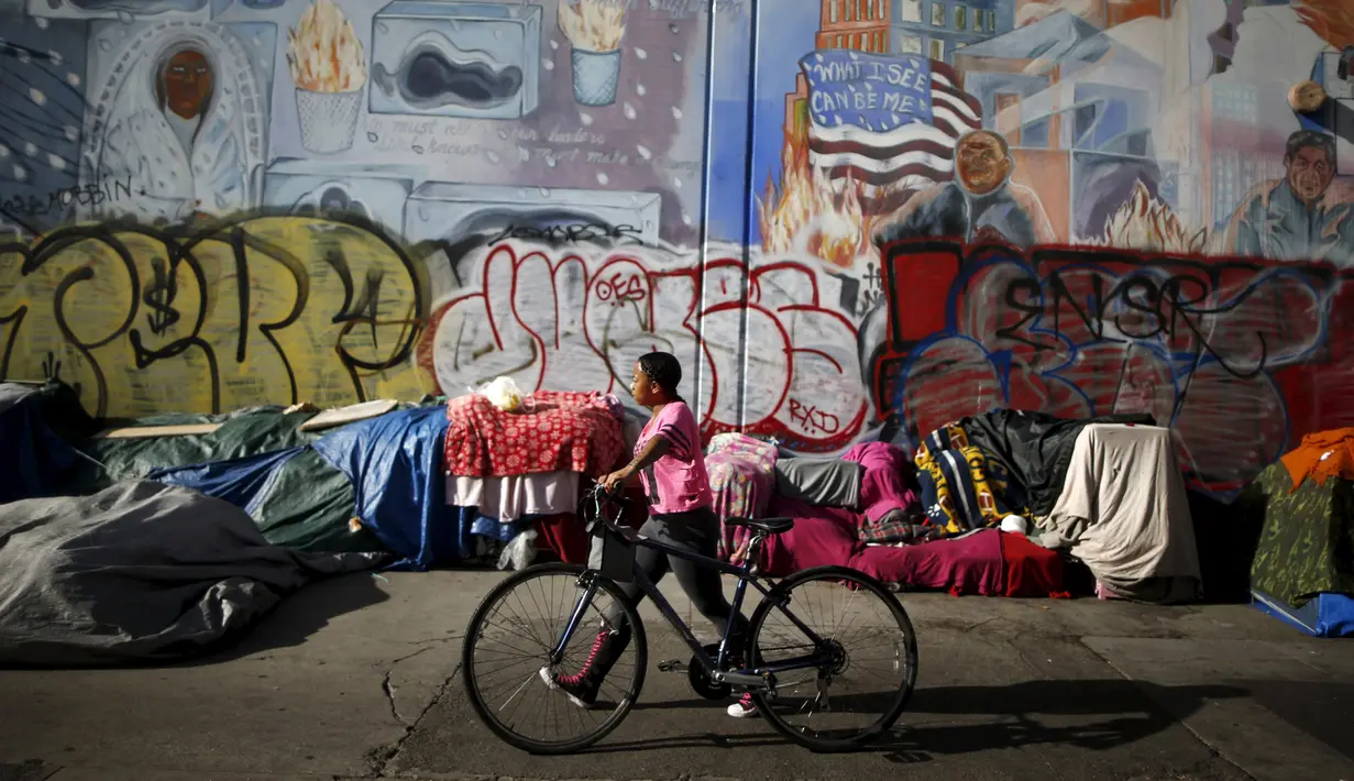 Warga berjalan melewati tenda yang ditempati kaum tunawisma di Skid Row, Los Angeles, California, Kamis (1/10/2015). Kota Los Angeles menetapkan status darurat terkait makin rumitnya persoalan kaum tunawisma di sana. (REUTERS/Lucy Nicholson)
