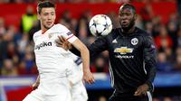 Pemain Manchester United Romelu Lukaku dan pemain Sevilla Clement Lenglet berebut bola pada laga leg pertama 16 besar Liga Champions di Ramon Sanchez Pizjuan, Rabu (21/2). Sevilla dan Manchester United sama-sama gagal mencetak gol. (AP/Miguel Morenatti)