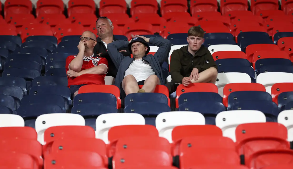 Suporter Inggris bereaksi setelah Italia memenangkan pertandingan final Euro 2020 di Stadion Wembley, London, Inggris, Minggu (11/7/2021). Italia mengalahkan Inggris 3-2 dalam adu penalti setelah pertandingan berakhir dengan skor 1-1. (Carl Recine/Pool Photo via AP)