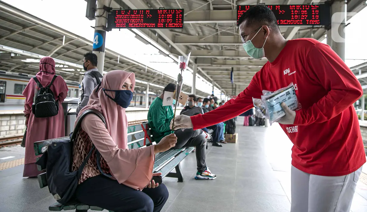 Petugas KAI Commuter (kanan) memberikan bunga dan healthy kit kepada perempuan pengguna KRL di Stasiun Jatinegara, Jakarta, Selasa (22/12/2020). Kegiatan tersebut dalam rangka memperingati Hari Ibu yang jatuh setiap tanggal 22 Desember. (Liputan6.com/Faizal Fanani)