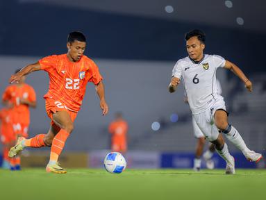 Pemain Timnas Indonesia U-22, Rabi Darwis (kanan) berebut bola dengan pemain India, Thingujam Korou Singh dalam laga uji coba di Stadion Madya, Senayan, Jakarta, Minggu (13/10/2025). (Bola.com/Bagaskara Lazuardi)