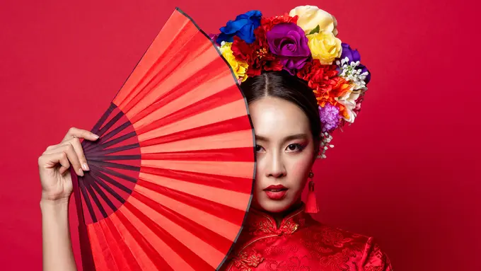 perempuan memegang kipas baju merah