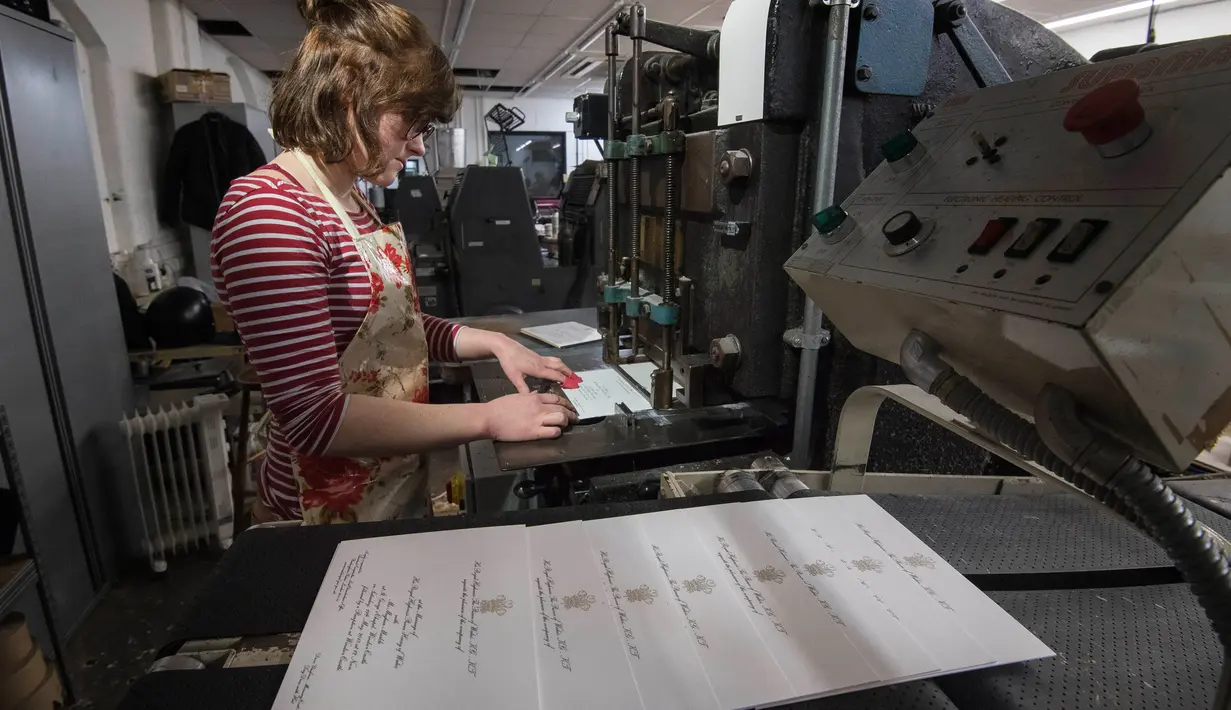 Lottie Small membuat undangan Pangeran Harry dan Meghan Markle menggunakan proses tradisional die-stamping, di bengkel Barnard and Westwood, London, Kamis (22/3).  Undangan dibuat dengan memberikan kehormatan kepada tempat asal dua mempelai. (AP Photo)