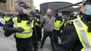 Seorang demonstran diamankan oleh para petugas polisi dalam aksi protes anti-lockdown di London, Inggris,  28 November 2020. Lebih dari 60 orang ditangkap saat bentrokan antara sejumlah demonstran anti-lockdown dan polisi terjadi di pusat kota London pada Sabtu (28/11). (Xinhua/Ray Tang)