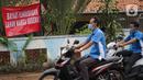 Pengendara motor melintas di depan poster protes warga terhadap pembangunan flyover di kawasan Tanjung Barat, Jakarta, Rabu (15/7/2020). Dalam poster protes tersebut, warga menuntut agar pembayaran pelunasan pembebasan lahan segera diselesaikan secara serentak. (Liputan6.com/Immanuel Antonius)