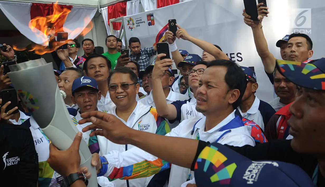 Wali Kota Bogor, Bima Arya Sugiarto menerima obor Asian Games 2018 di rumah dinas wali kota, Jawa Barat, Selasa (14/8). Kirab obor Asian Games mengelilingi pusat Kota Bogor dengan rute sepanjang 10 kilometer secara estafet. (Merdeka.com/Arie Basuki)