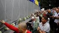 Warga menyentuh truk yang membawa 136 peti korban pembantaian Srebrenica pada Juli 1995, di desa Visoko , Bosnia-Herzegovina, Kamis, (9/7/2015). Ribuan orang tewas dan menjadi yang terburuk di Eropa sejak Perang Dunia II. (REUTERS/Stoyan Nenov)