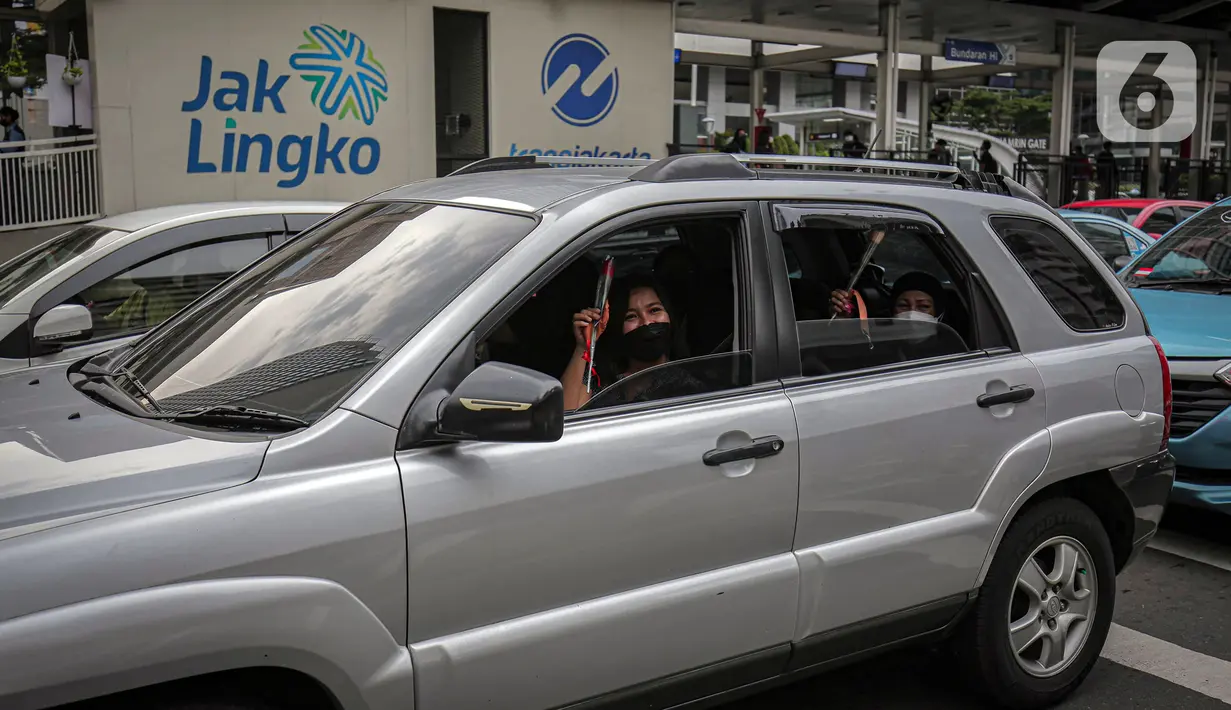Pengguna jalan mendapat bunga dan masker yang dibagikan perserta Forum Kader Bela Negara DKI Jakarta di Jalan Thamrin, Jakarta, Rabu (22/12/2021). Aksi tersebut merupakan bentuk apresiasi terhadap kaum perempuan terutama pada peringatan Hari Ibu. (Liputan6.com/Faizal Fanani)