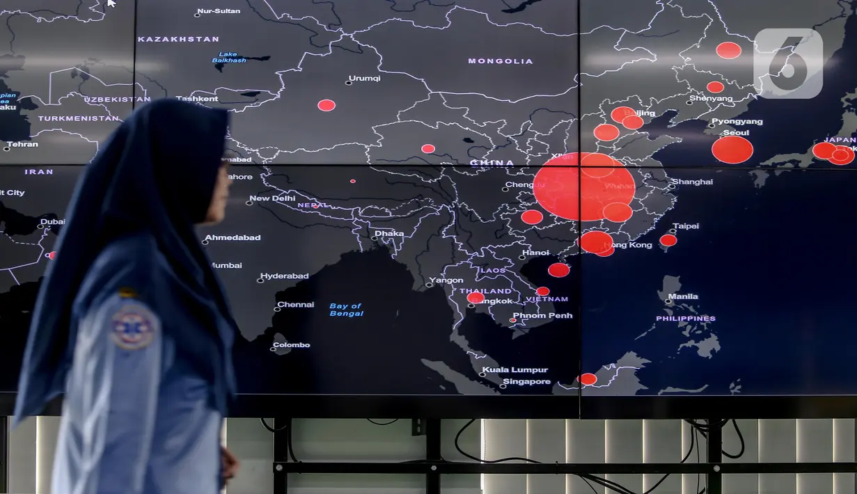 Petugas melewati layar pemantau yang menunjukan penyebaran virus corona (COVID-19) di Dinas Kesehatan DKI Jakarta, Senin (9/3/2020). Dari 3.580 orang yang menghubungi Posko COVID-19 DKI Jakarta, ada 64 kasus kategori Orang Dalam Pantauan dan 56 Pasien Dalam Pengawasan. (Liputan6.com/Faizal Fanani)