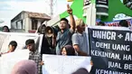 Para pengunjuk rasa memegang poster saat unjuk rasa di Sabang, Provinsi Aceh, Indonesia, Senin (18/12/2023). (AP Photo/Reza Saifullah)