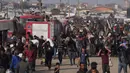 Warga Palestina membawa kotak dan tas berisi makanan dan paket bantuan kemanusiaan yang dikirim oleh Yayasan Kemanusiaan Gaza, organisasi yang didukung Amerika Serikat (AS) dan disetujui oleh Israel, di Khan Younis, Jalur Gaza selatan, Minggu 1 Juni 2025. (AP Photo/Abdel Kareem Hana)
