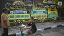 Warga melintas dekat karangan bunga atas meninggalnya istri Indro Warkop, Nita Octobijanthy yang terpajang di rumah duka kawasan Pulo Mas, Jakarta, Rabu (10/10). Istri Indro Warkop meninggal di usia 59 tahun akibat kanker. (Liputan6.com/Faizal Fanani)