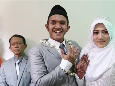 Komedian Caisar Aditya Putra dan Intan Sri Mardiani menunjukkan cincin usai ijab kabul pernikahan di kawasan Cimahpar, Bogor, Jawa Barat, Sabtu (30/6). Caisar resmi menikahi Intan usai bercerai dari Indadari. (Liputan6.com/Herman Zakharia)