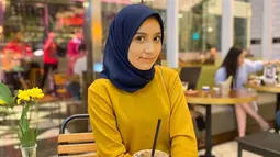 Saat hangout ke kafe bareng bestie, Amira lebih memilih bergaya simpel. Seperti pada potretnya kali ini. Istri pedangdut yang kini memiliki pengikut 33ribu lebih di Instagram itu memakai kaus berwarna gold, yang dipadukan dengan hijab navy. Polesan makeup-nya pun terlihat begitu natural. (Liputan6.com/IG/@amira_krmn)