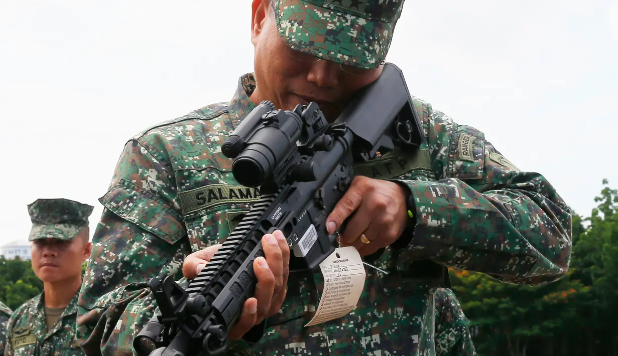 Komandan Korps Marinir Filipina, Mayjen Emmanuel Salamat memeriksa senjata laras panjang pemberian AS di kota Taguig, sebelah timur Manila, Filipina (5/6). (AP Photo / Bullit Marquez)