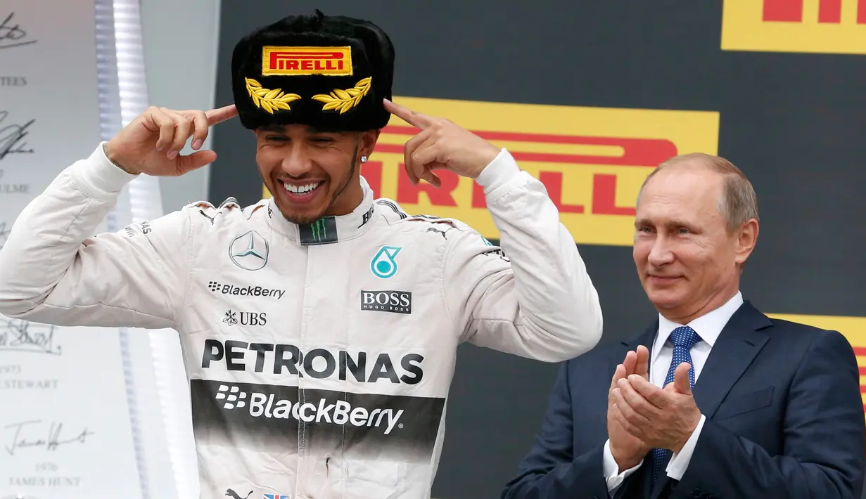 Presiden Russia, Vladimir Putin melihat pembalap F1 tim Mercedes, Lewis Hamilton merayakan kemenangannya di atas podium usai menjadi juara ajang balap GP Formula 1 Rusia di Sochi, Minggu (11/10/2015). (REUTERS/Grigory Dukor)