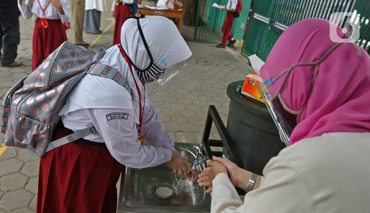 Seorang murid mencuci tangan sebelum memasuki sekolah  SD Negeri 6, Bekasi, Jawa Barat, Selasa (4/8/2020). Pemerintah setempat memberikan izin kepada enam sekolah untuk melakukan uji coba pembelajaran tatap muka selama satu bulan. (Liputan6.com/Herman Zakharia)