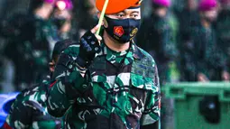 Pasukan TNI memayungi diri menggunakan daun saat mengikuti gelar pasukan dalam rangka pengetatan PPKM Mikro DKI Jakarta di Lapangan Monas, Jakarta, Jumat (18/6/2021). Gelar pasukan diikuti oleh TNI, Polri, dan Satpol PP. (Liputan6.com/Faizal Fanani)
