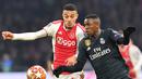 Duel antara Vinicius Jr dan Mazraoiu pada leg 1, 16 besar Liga Champions yang berlangsung di stadion Amsterdam Arena, Amsterdam, Kamis (14/2). Real Madrid menang 2-1 atas Ajax. (AFP/Emmanuel Dunand)
