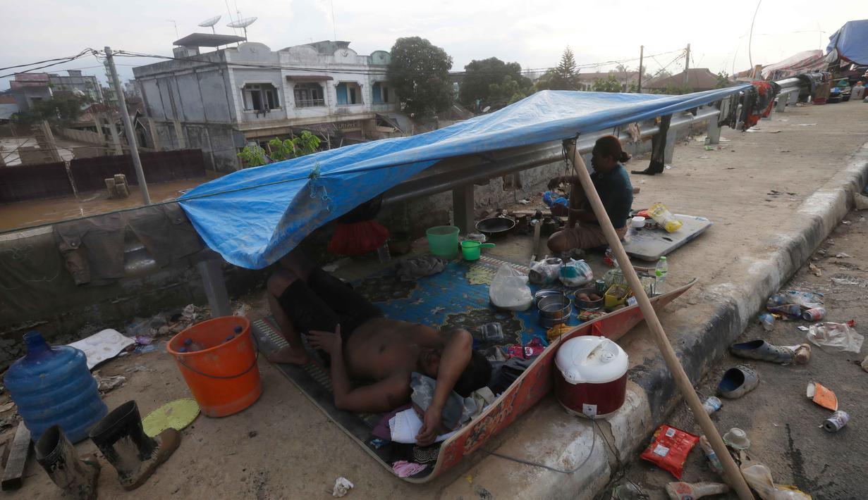Meski demikian, beberapa ruas jalan utama sudah dapat dilalui. Tampak dalam foto, para penyintas banjir berlindung di tenda darurat di Aceh Tamiang, Sumatera, Kamis 4 Desember 2025. (AP Photo/Binsar Bakkara)