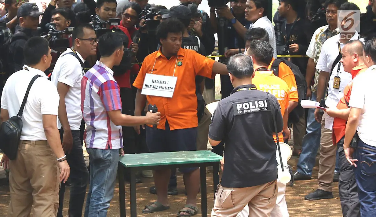 Tersangka insiden penembakan peluru nyasar di ruangan anggota DPR, IAW, menjalani proses rekonstruksi Lapangan Tembak Senayan, Jakarta, Jumat (19/10). IAW dan RMY merupakan Pegawai Negeri Sipil Kementrian Perhubungan. (Liputan6.com/Immanuel Antonius)
