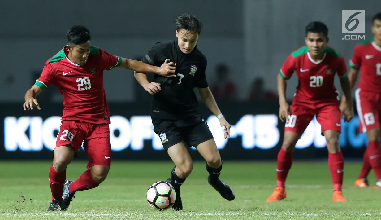Pemain belakang Indonesia U-19, Firza Andika (kiri) menahan pergerakan gelandang Thailand U-19, Robin Kjel Holm pada laga persahabatan di Stadion Wibawa Mukti, Cikarang, Jawa Barat, Minggu (8/10). Indonesia menang 3-0. (Liputan6.com/Helmi Fithriansyah)