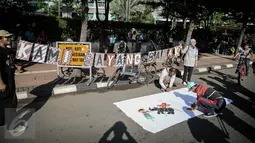 Warga menandatangani kain putih sebagai dukungan saat aksi 'Kami Sayang Badak' pada Car Free Day di kawasan Bunderan HI, Jakarta, (27/3). Aksi tersebut guna Memperingati hari bumi dan kampanye Badak yang hampir punah. (Liputan6.com/Faizal Fanani)