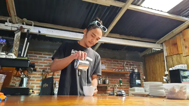 Barista Pustaka Coffee sedang menuangkan krimer ke dalam minuman pesanan pelanggan (Liputan6.com/Rino Abonita))