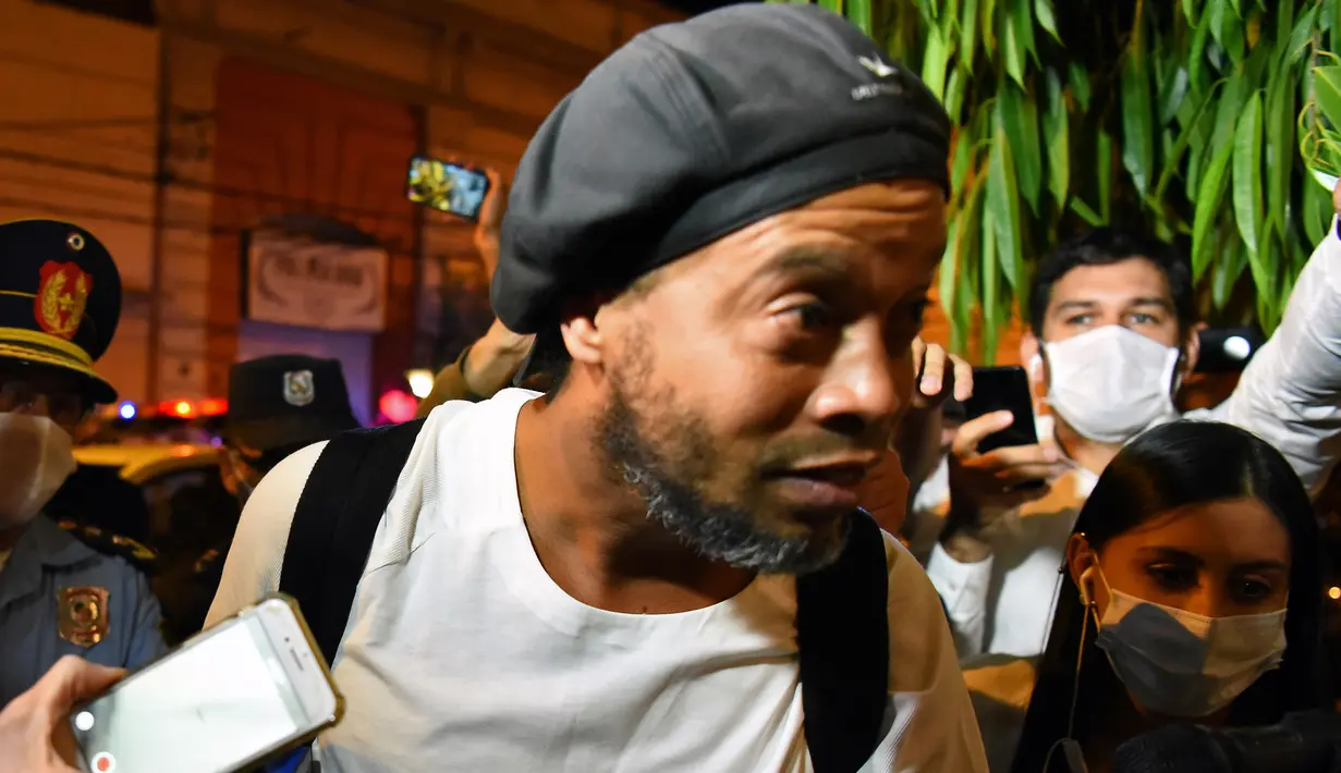 Mantan pemain timnas Brasil, Ronaldinho tiba di sebuah hotel untuk menjalani tahanan rumah di Asuncion, Paraguay, Selasa (7/4/2020). Ronaldinho kini berstatus tahanan kota setelah dibebaskan dari penjara dengan membayar uang jaminan sebesar sekitar Rp 25 miliar. (Norberto DUARTE / AFP)