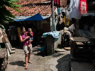 Pejalan kaki melintasi gang menuju rumah yang pernah ditempati Siti Aisyah, WNI yang diduga terlibat pembunuh Kim Jong-nam, kakak tiri pemimpin Korea Utara Kim Jong-un, di Gang Kacang, Kelurahan Angke, Jakarta, Jumat (17/2). (Liputan6.com/Gempur M Surya)