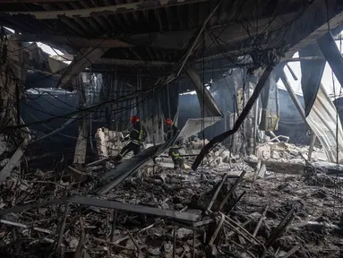 Para petugas penyelamat dari Layanan Darurat Negara Ukraina berjalan melewati reruntuhan bangunan yang rusak parah di Odesa pada Jumat 13 Februari 2026. Gelombang serangan udara besar-besaran Rusia kembali menghantam sejumlah wilayah di Ukraina pada Kamis 12 Februari 2026. (Oleksandr GIMANOV/AFP)
