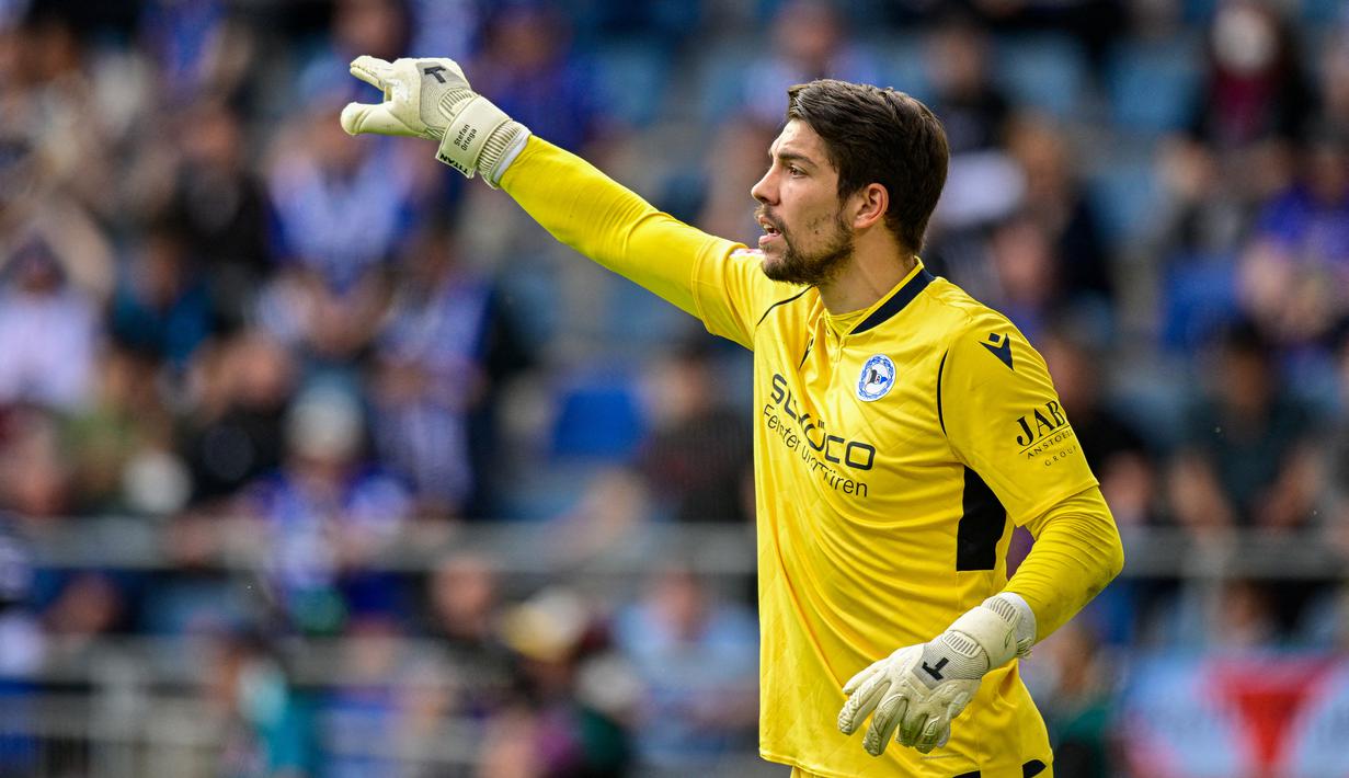 Stefan Ortega. Kiper Jerman berusia 29 tahun ini baru saja didatangkan Manchester City untuk mengarungi musim 2022/2023 dengan status bebas transfer usai kontraknya habis bersama Arminia Bielefeld yang terdegradasi dari Bundesliga. Ia dikontrak hingga Juni 2025 dan diplot untuk menggantikan kiper kedua Mancity, Zack Steffen yang bakal dilepas dalam waktu dekat. Selama 8 musim berseragam Arminia Bielefeld dalam dua periode, Stefan Ortega total tampil dalam 220 laga di semua ajang dengan torehan 65 kali clean sheet dan kebobolan 299 gol. (AFP/Sascha Schuermann)